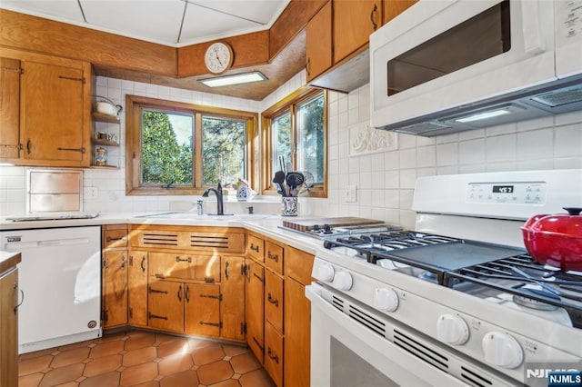 kitchen with white appliances, light countertops, tasteful backsplash, and a sink