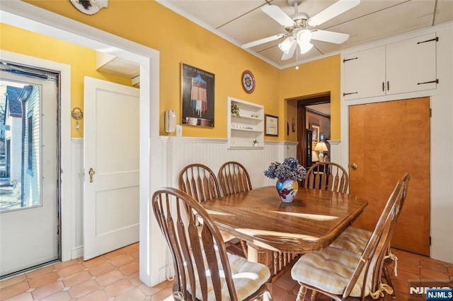 dining area featuring plenty of natural light, wainscoting, ceiling fan, and ornamental molding