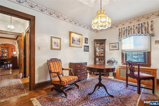 office with hardwood / wood-style floors, an inviting chandelier, baseboards, and arched walkways