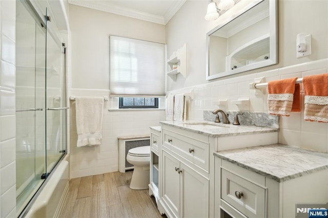 full bath featuring toilet, wood finished floors, tile walls, crown molding, and vanity