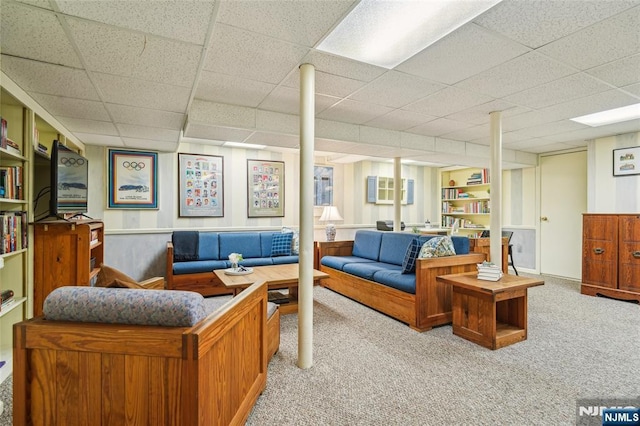 carpeted living room featuring a drop ceiling