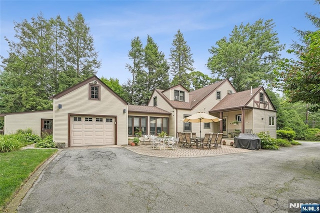 view of front of home featuring aphalt driveway and a patio