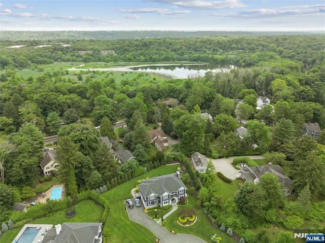 aerial view featuring a wooded view and a water view