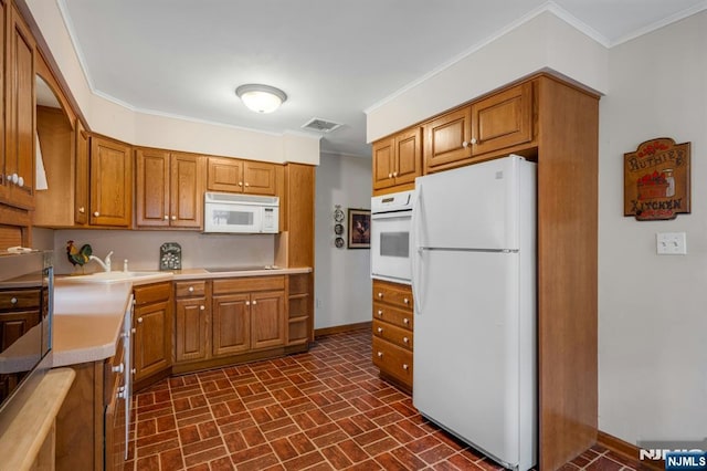 kitchen featuring white appliances, baseboards, ornamental molding, and a sink