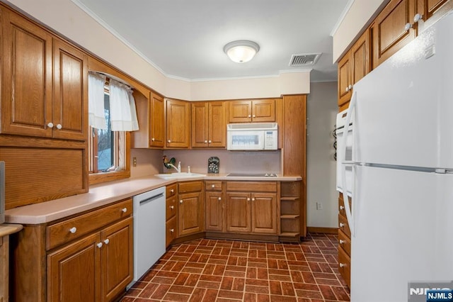 kitchen featuring white appliances, a sink, visible vents, brown cabinetry, and crown molding