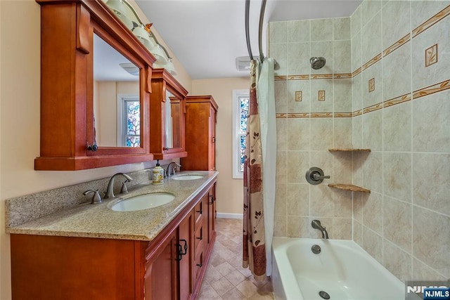 bathroom with double vanity, shower / tub combo, a sink, and baseboards