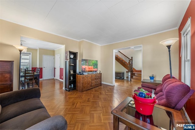 living area with baseboards, stairway, and crown molding