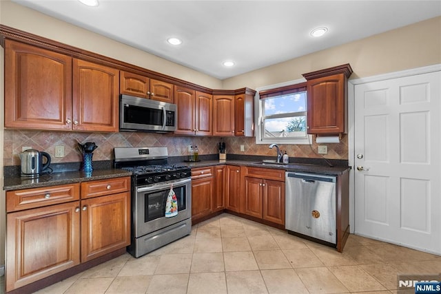 kitchen featuring appliances with stainless steel finishes, brown cabinetry, and a sink