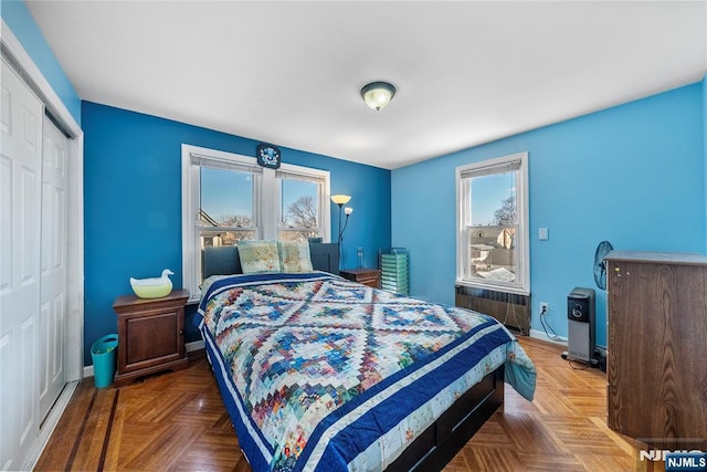 bedroom featuring baseboards, a closet, and radiator