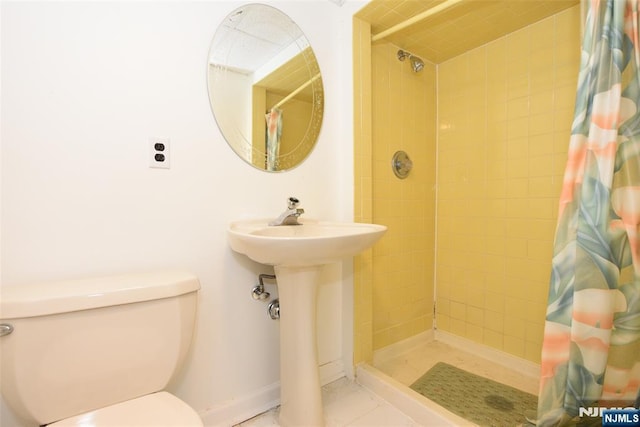 bathroom featuring tiled shower and toilet