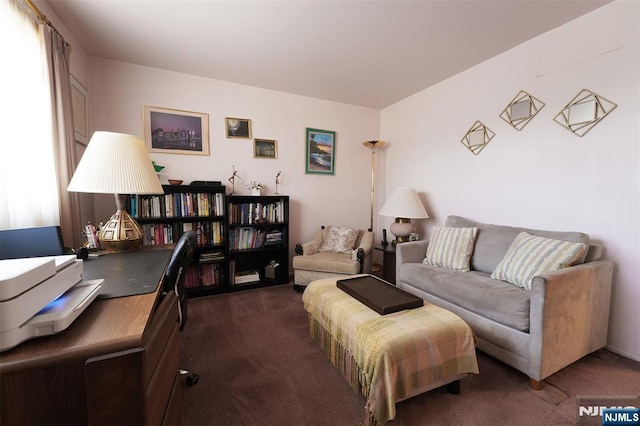 living area featuring plenty of natural light and dark carpet