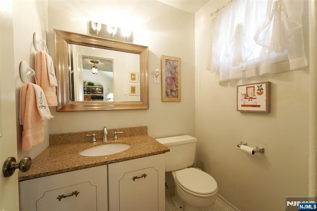 bathroom with baseboards, vanity, and toilet