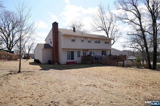 rear view of property featuring a chimney and a deck