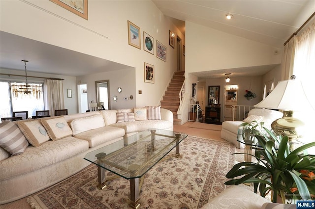 living area featuring stairs, high vaulted ceiling, and a notable chandelier