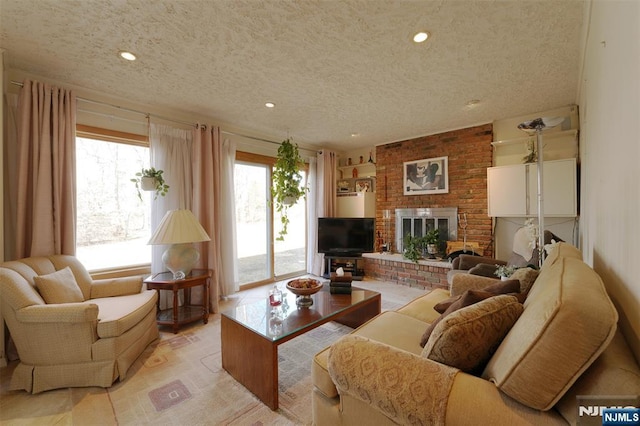 living room featuring recessed lighting, a fireplace, and a textured ceiling