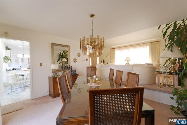 dining area featuring a notable chandelier and carpet flooring