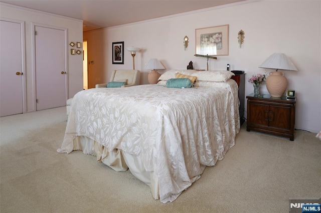 bedroom featuring crown molding and light colored carpet