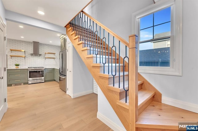 stairway featuring recessed lighting, wood finished floors, and baseboards