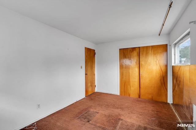 unfurnished bedroom with a closet and carpet flooring