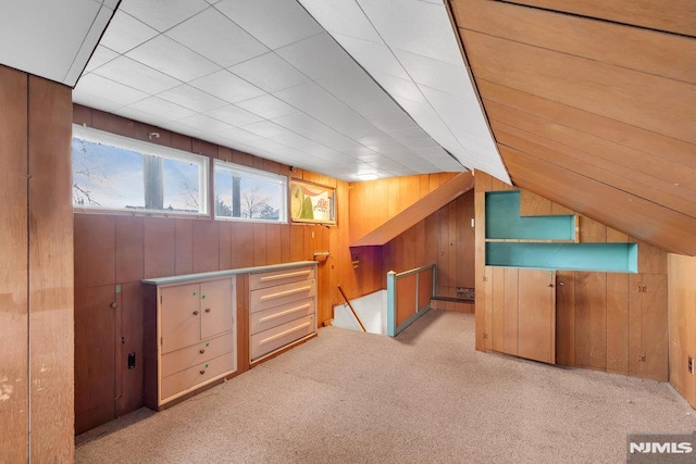 bonus room with light carpet, lofted ceiling, and wooden walls