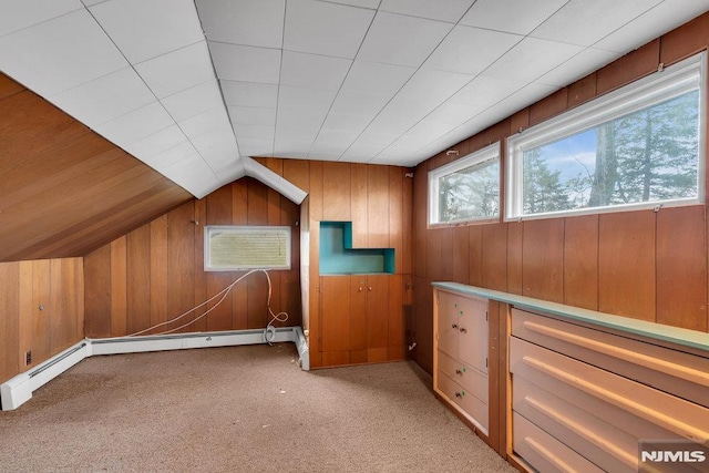 additional living space featuring lofted ceiling, light colored carpet, and wooden walls