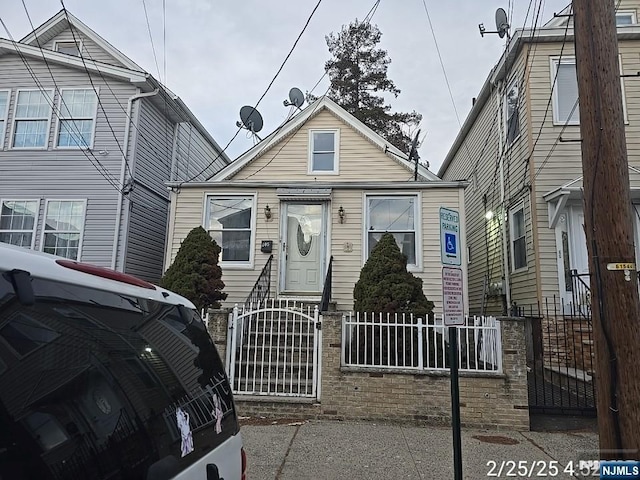 view of front of property featuring a fenced front yard and a gate