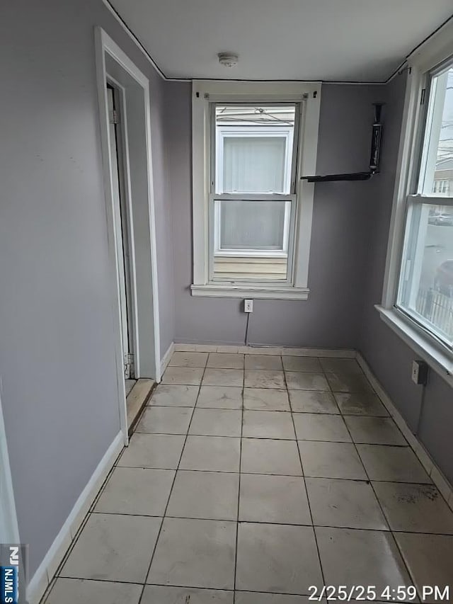 interior space with light tile patterned floors and baseboards