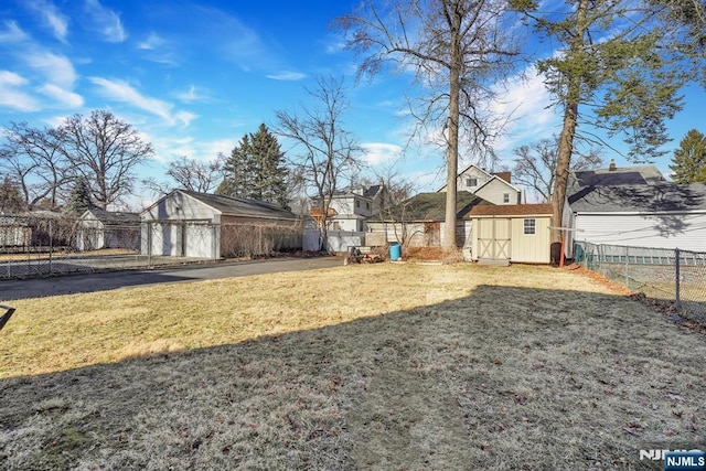 view of yard featuring an outbuilding, a fenced backyard, and a shed