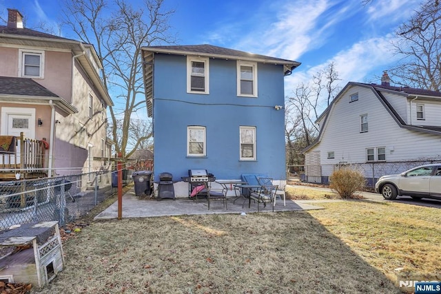 back of house featuring stucco siding, a fenced backyard, a patio, and a lawn