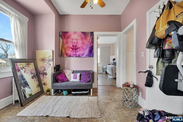 sitting room with a ceiling fan and baseboards