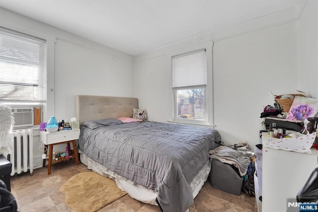 bedroom featuring radiator heating unit and cooling unit