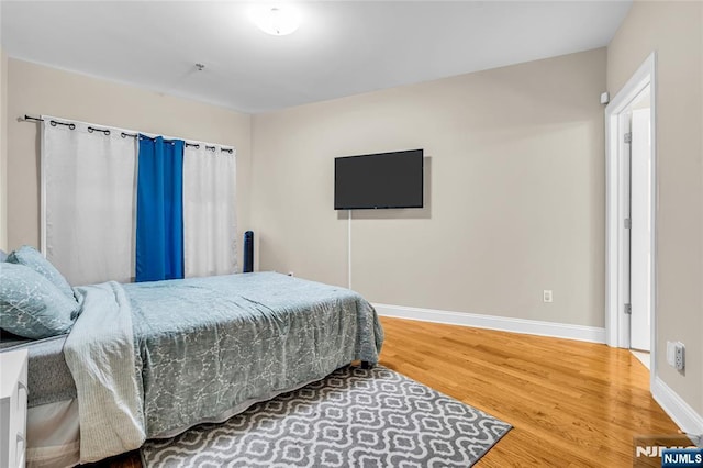 bedroom featuring baseboards and wood finished floors