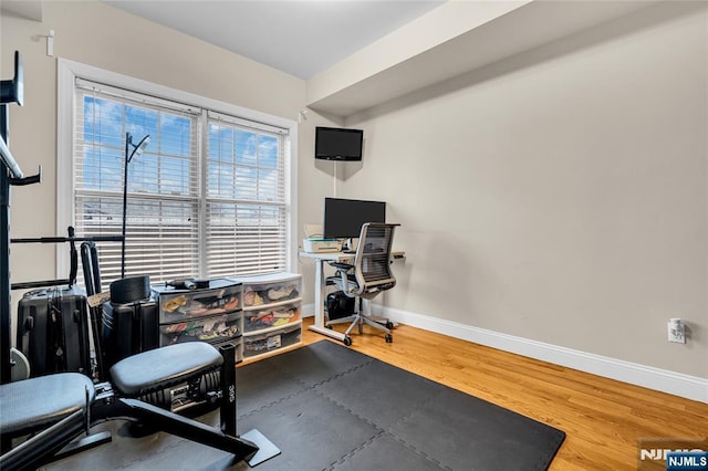 home office with baseboards and wood finished floors