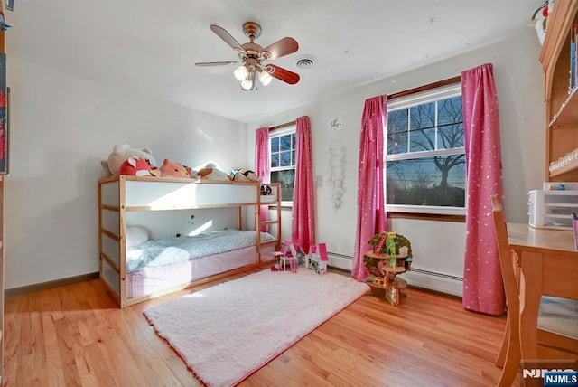 bedroom with ceiling fan, wood finished floors, visible vents, and baseboards