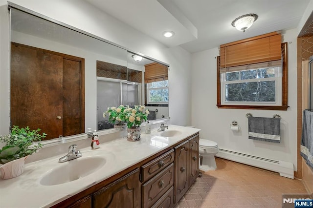 full bathroom with a sink, a shower stall, toilet, and a baseboard radiator