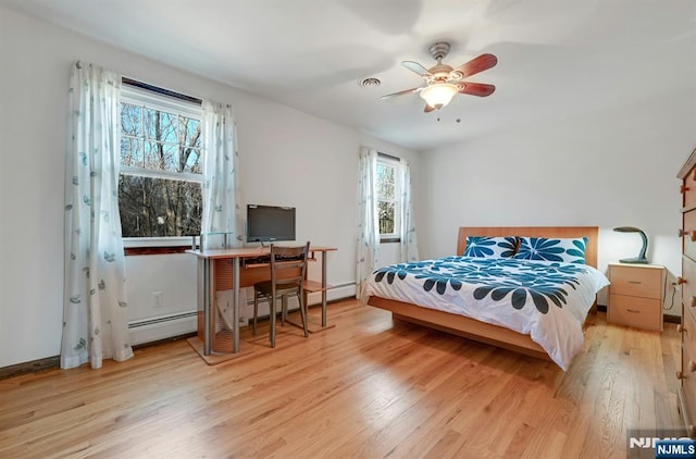 bedroom with baseboards, visible vents, ceiling fan, light wood-style floors, and baseboard heating