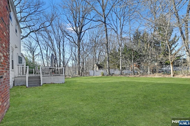 view of yard featuring a wooden deck and fence