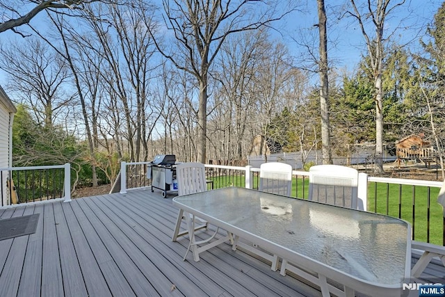 wooden terrace with a yard, outdoor dining space, and fence