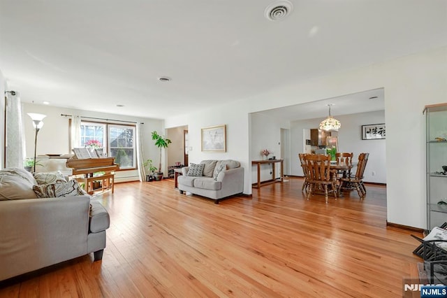 living area featuring visible vents, baseboards, and light wood-style flooring