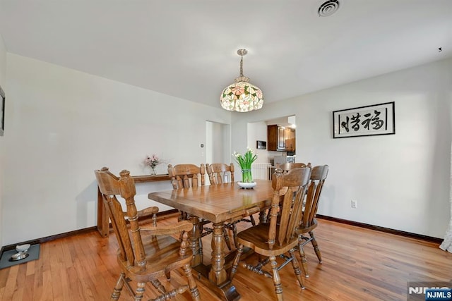 dining room with visible vents, light wood-style flooring, and baseboards