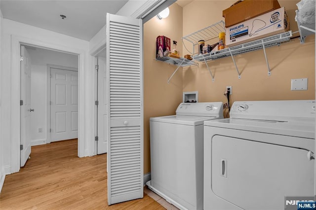 laundry room with laundry area, light wood-style flooring, and separate washer and dryer