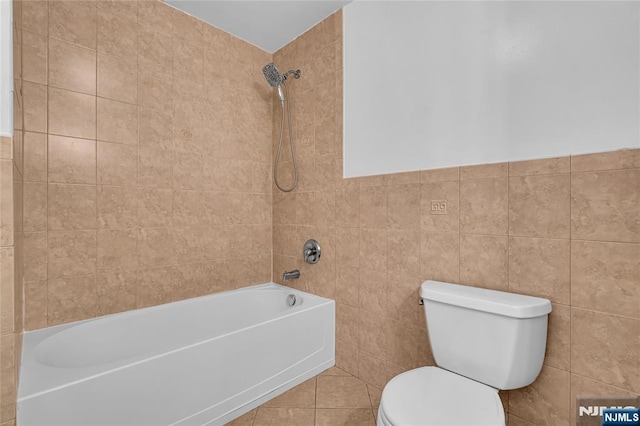 bathroom with toilet, bathtub / shower combination, tile walls, and wainscoting