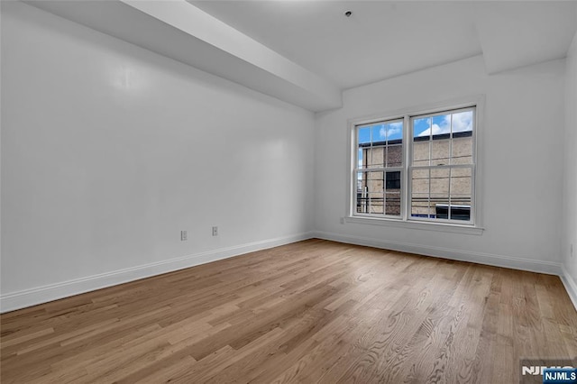 empty room featuring baseboards and wood finished floors