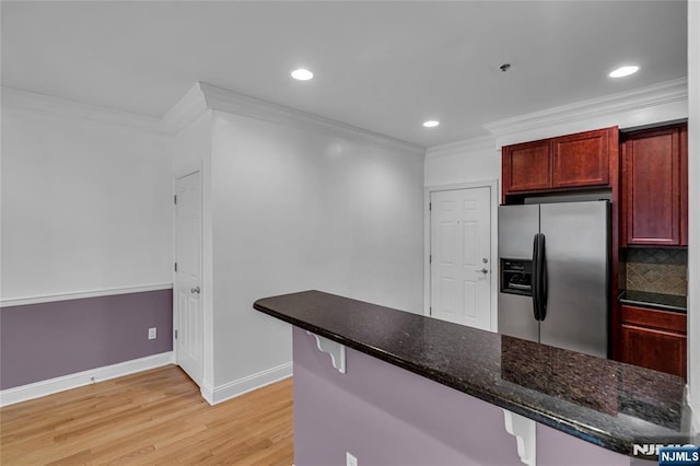 kitchen with reddish brown cabinets, light wood finished floors, decorative backsplash, crown molding, and stainless steel refrigerator with ice dispenser