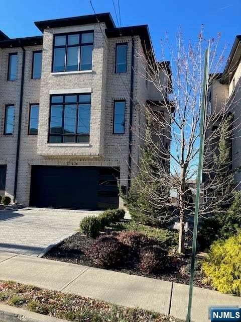 view of front of property with brick siding, decorative driveway, and an attached garage