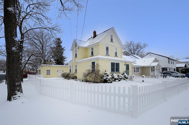 view of front of home with a fenced front yard and a chimney