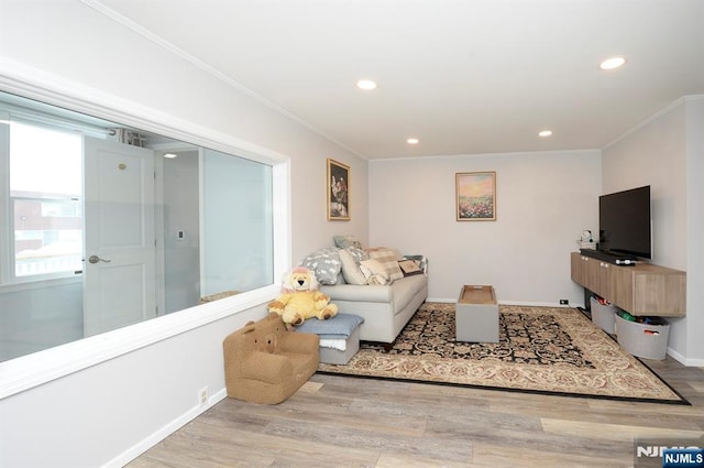 living area featuring baseboards, recessed lighting, wood finished floors, and crown molding