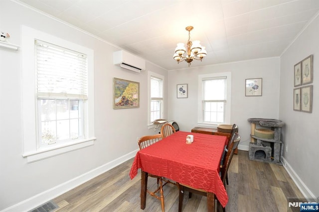 dining area with a wall mounted air conditioner, crown molding, baseboards, and wood finished floors