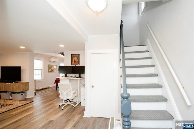 staircase featuring recessed lighting, wood finished floors, a ceiling fan, ornamental molding, and a wall mounted AC