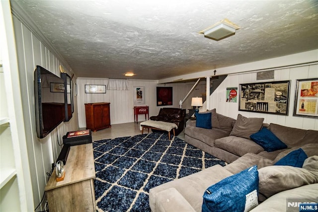 living area featuring stairway and a textured ceiling